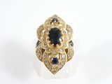 une photo d'une bague sertie d'un diamant et d'un saphir sur un fond blanc