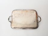 an old silver tray with handles on a white surface