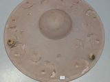 une assiette rose posée sur une table blanche, sur laquelle est collé un autocollant