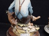 two figurines of a man and a dog on a table