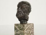 une sculpture représentant la tête d'un homme sur un bloc de marbre