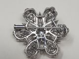 a close up of a silver snowflake on a white surface