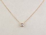 un collier en or orné d'un diamant blanc, monté sur une chaîne en or