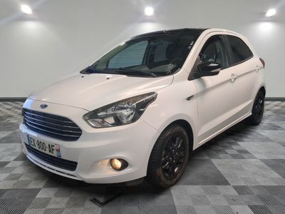 La Ford Karry blanche est garée dans une pièce au sol à carreaux.