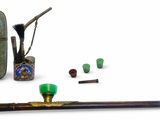 une petite collection d'objets comprenant une pipe, un étui et une batte de baseball