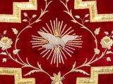 embroidered applique with a dove and flowers on a red background