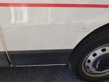 a white van with a red stripe parked on the side of the road