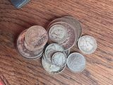 une pile de pièces posée sur une table à côté d'un portefeuille