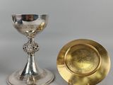 deux gobelets en argent et en or et une assiette en or posés sur une table