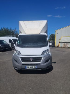 une camionnette blanche garée sur un parking à côté d'un bâtiment