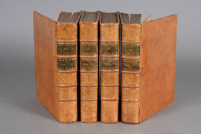 three old books are stacked on top of each other on a table