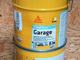 un bidon jaune de peinture de garage posé sur un plancher en bois