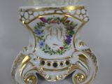 a white and gold vase with flowers on it