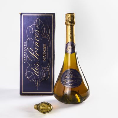 La bouteille de champagne se trouve à côté d'une boîte de chocolats