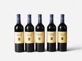four bottles of wine are lined up on a white surface