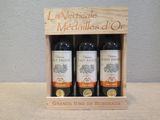 trois bouteilles de vin dans un coffret en bois sur une table