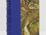 a blue book with a gold and blue cover sitting on a table