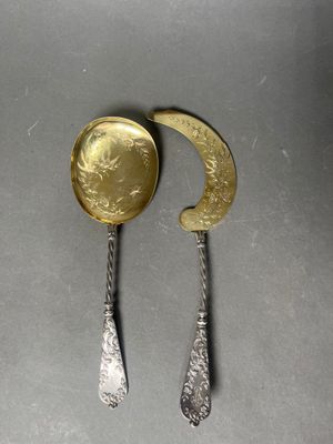 two spoons and a spoon with a gold coin on them