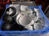 a blue basket full of dishes and bowls on a table