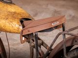 a brown bag on the back of an old motorcycle