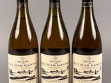 trois bouteilles de vin posées sur une table l'une à côté de l'autre