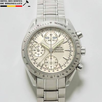 une montre en argent avec un cadran blanc posée sur une surface blanche
