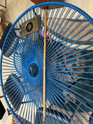 a blue fan sitting on top of a table next to a chair