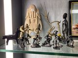 de nombreuses figurines posées sur une étagère en verre, avec une photo en arrière-plan