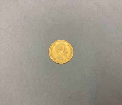 une pièce d'or posée sur une surface grise