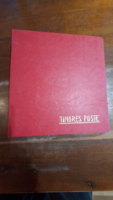 un livre rouge posé sur une table en bois
