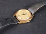an image of a gold wrist watch with a black leather strap