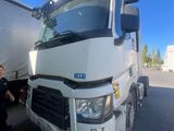 un homme debout à côté d'un gros camion sur un parking