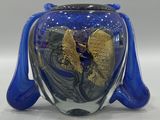 a blue vase with a gold leaf inside of it