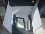 a white box with a mirror inside of it on a tiled floor