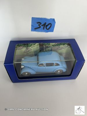La petite voiture bleue se trouve dans une boîte bleue sur laquelle est apposée une étiquette de prix.