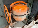 an orange cement mixer sitting in the corner of a room