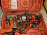 une mallette orange posée par terre, contenant des outils