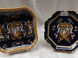 deux assiettes ornées de motifs dorés et bleus, posées sur une surface blanche
