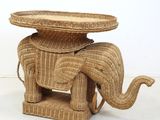 a wicker elephant with a basket on top of it