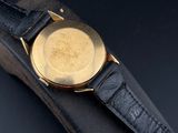 a close up of a watch on a black leather strap