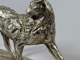 silver statue of a dog on a wooden base on a white background