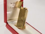 a gold lighter in a red box on a white surface