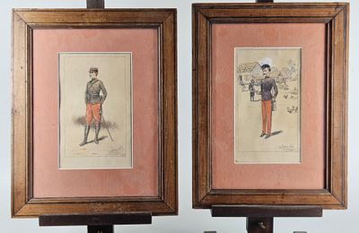 two framed prints of men in military uniforms are on a table