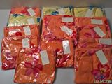 plusieurs sacs contenant des vêtements orange et jaunes, avec leurs étiquettes de prix