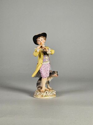 une figurine représentant un garçon et un chien posée sur une table