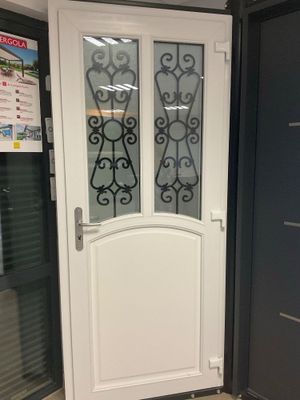 une porte blanche ornée d'un vitrail sur le côté