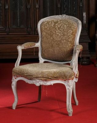 une chaise qui se trouve dans une pièce recouverte d'un tapis rouge