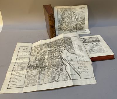 deux vieilles cartes sont posées sur une table à côté d'une lampe