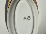 a white plate with a gold edge and a bowl on it