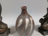 three small vases sitting next to each other on a white surface